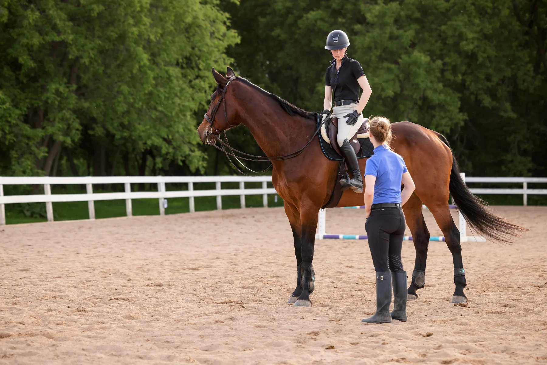 A coach speaking with a rider on horseback